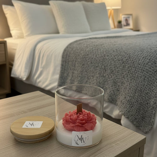 Velvet rose candle placed on a side table with wooden cap beside it