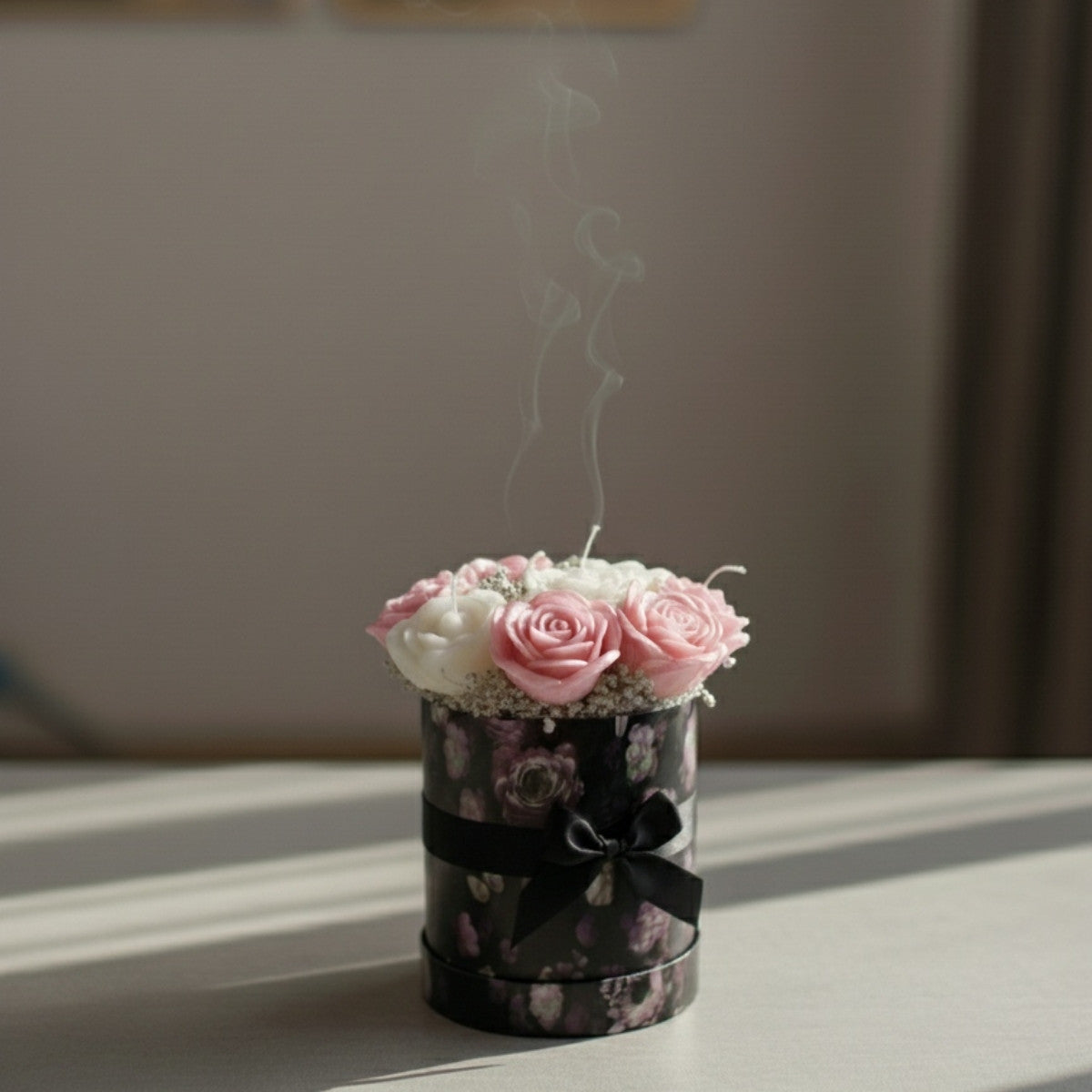 Decorative box with pink and white flowers emitting smoke on a light surface