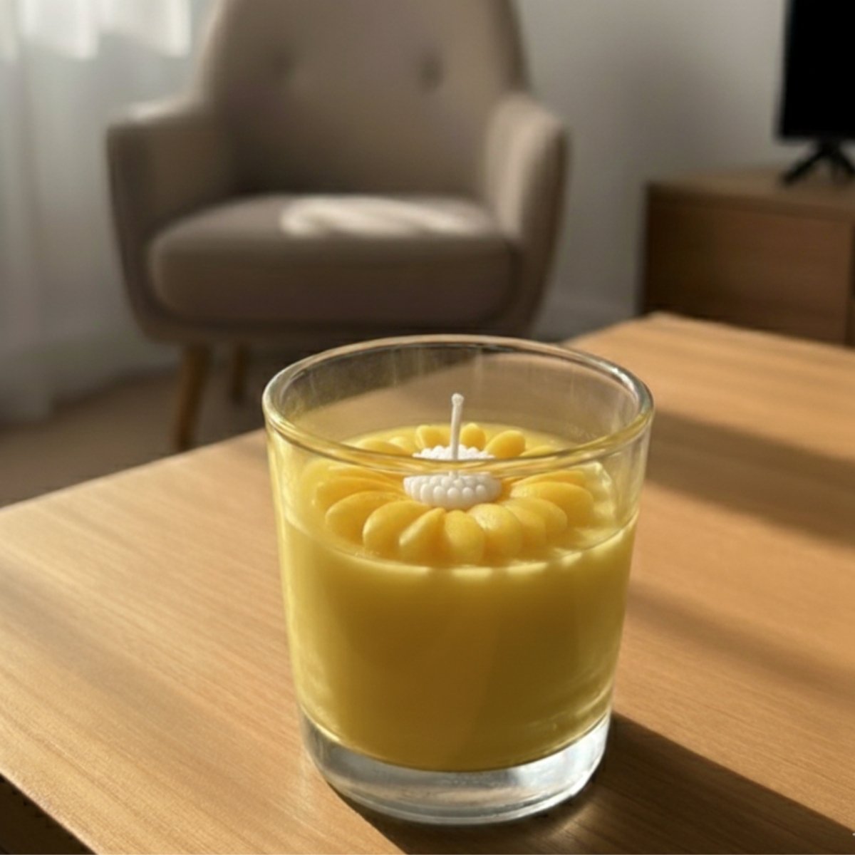 Yellow candle in a glass holder on a wooden table with a blurred chair and curtain in the background